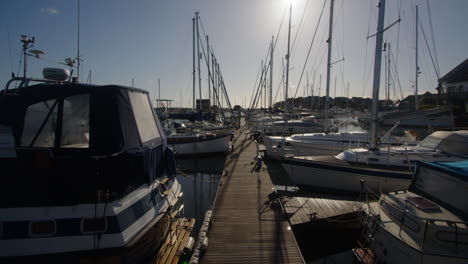 shot-looking-down-a-pontoon-full-of-sailboats-at-Hythe-Marinapontoon,-Hythe-Marina-village,-houses,-boats,-Sailboats,-locks,-Solent,-sea,-Hythe,-Marina,-FHV23,-UK,-autumn