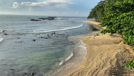 Establishing-Static-Handheld-Shot-of-Sandy-Beach-in-Sri-Lanka-at-Golden-Hour-with-Small-Waves
