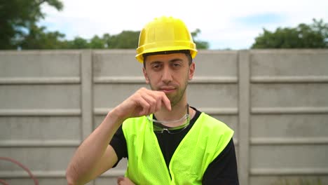 A-Construction-Worker,-Wearing-a-Yellow-Hard-Hat-with-Standard-Safety-Spectacles-Positioned-on-His-Neck,-is-Demonstrating-Proper-Hat-Etiquette---Medium-Close-Up