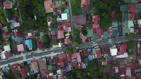 Top-down-drone-shot-of-Philippine-Provincial-Highway-with-cars,-surrounded-by-trees-and-houses