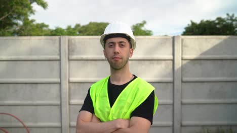 An-Engineer,-Wearing-a-White-Hard-Hat,-Crosses-his-Arms-Over-his-Chest---Medium-Close-Up