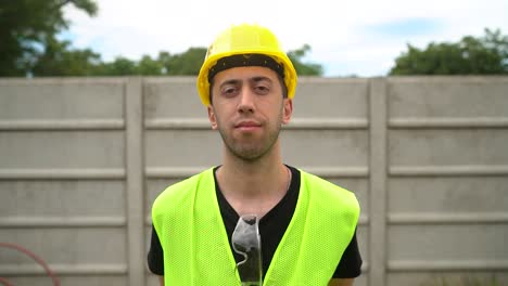 Ein-Bauarbeiter-Mit-Gelbem-Schutzhelm-Positionierte-Seine-Standard-Schutzbrille-Auf-Dem-Ausschnitt-Seines-Hemdes-–-Mittlere-Nahaufnahme