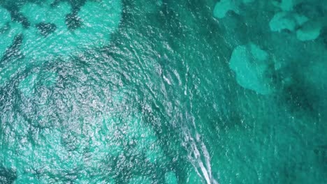 Bird-eye-aerial-over-turquoise-blue-waters-of-the-Caribbean-Sea,-near-Cancun's-hotel-zone