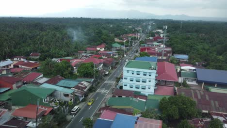 Drone-shot-of-Philippine-Province-small-highway-road,-surrounded-by-houses-and-trees