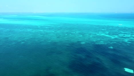Aerial-over-turquoise-blue-waters-of-the-Caribbean-Sea,-near-Cancun's-hotel-zone