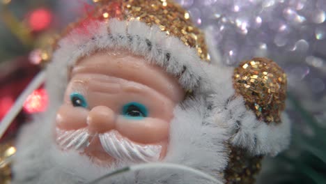 X-mas-golden-plastic-Santa-Claus,-big-white-beard,-blue-eyes,-Christmas-decoration,-traditional-holiday-new-year-decor,-shiny-colorful-setup,-cinematic-creative-slow-macro-pan-right-shot,-4K-video