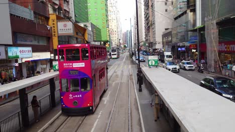 POV-Perspektive-Von-Der-Rückseite-Der-Straßenbahn-Aus,-Die-Entlang-Der-überfüllten-Autostraße-Im-Stadtbild-Der-Innenstadt-Von-Hongkong-Fährt