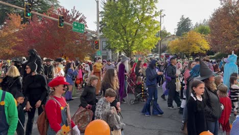 A-Crowd-Celebrating-Halloween-walking-in-a-crosswalk-in-Ashland,-Oregon