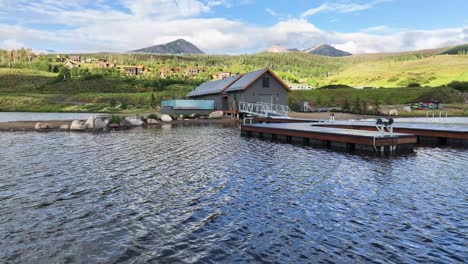 boat-house-lake-house-with-a-boat-dock-on-a-lake-with-Buffalo-Mountain-in-the-background-located-in-Silverthorne-colorado-AERIAL-ORBIT