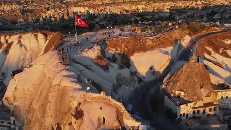 Fliegen-über-Die-Berühmten-Felsformationen-Kappadokiens-Mit-Touristen-überall-Und-Der-Türkischen-Roten-Flagge