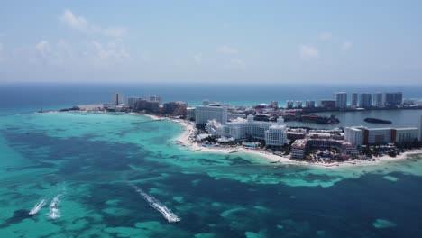 Rotating-aerial-over-Cancun-hotel-zone,-a-haven-for-sun-seekers-and-vacation-enthusiasts,-stunning-array-of-high-rise-hotels-and-resorts-that-stand-like-beacons-of-luxury-along-the-coast