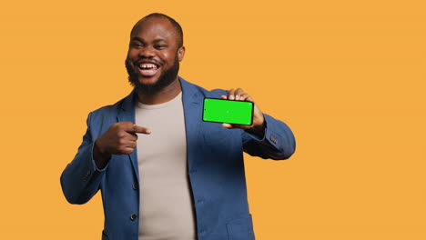 Portrait-of-man-doing-influencer-marketing-using-green-screen-phone