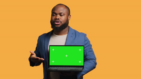 Portrait-of-man-doing-influencer-marketing-using-green-screen-laptop