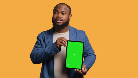 Portrait-of-man-doing-influencer-marketing-using-green-screen-tablet