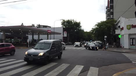 Buses-and-Cars-Drive-Through-Gaona-Avenue-Buenos-Aires-City-Gas-Station-Traffic-at-Daylight