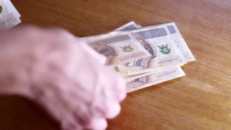Man-counts-money,-cash-Polish-zloty,-close-up-200-PLN,-money-on-the-table