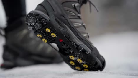 Showing-ice-spikes-below-shoes-in-close-up-slow-motion