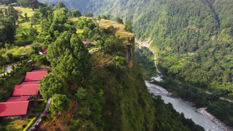 Aerial-revealing-shot-showing-village-in-top-hill-in-Pokhara-and-river-in-the-valley,-Nepal