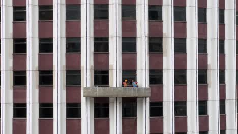 Window-Cleaners-Standing-on-Suspended-Platform-Cleaning-Skyscraper-Windows