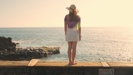 Junge-Frau-In-Sommerkleidung-Beobachtet-Den-Hellen-Sonnenaufgang-über-Dem-Leuchtenden-Meer