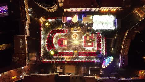 Top-down-view-Sibiu-Christmas-Fair,-Romania-at-night-time-with-festive-lights