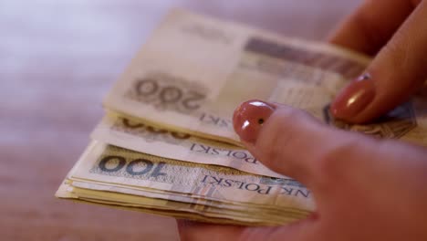 Woman-counts-money,-cash-Polish-zloty,-close-up-200-PLN,-financial-problems