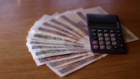 Polnisches-Geld-Liegt-Mit-Einem-Taschenrechner-Auf-Dem-Tisch,-Polnischer-Zloty-Zählt-Geld