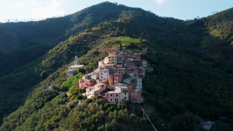 Kleines-Dorf-Am-Hang-Einer-Bergkette-Mit-Häusern-In-Vielen-Farben,-Drohnen-Tracking-Aufnahme