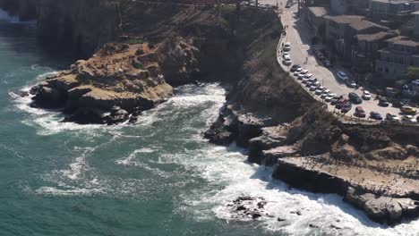 La-Jolla-Cove-and-beach-surrounded-by-cliffs-in-San-Diego,-California---aerial-reveal