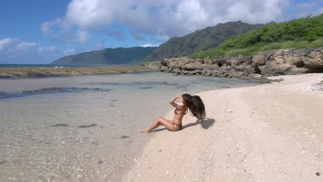 Die-Strandlandschaft-Wird-Durch-Eine-Sonnenverwöhnte-Schönheit-Mit-Langen-Schwarzen-Haaren-Und-Einem-Atemberaubenden-Braunen-Bikini-Hervorgehoben