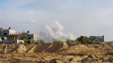 Smoke-above-a-burning-demolished-building-in-Gaza-strip,-establishing-shot