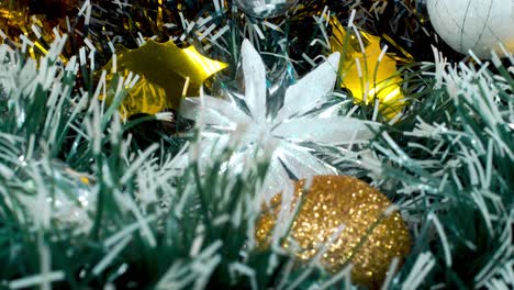 Weihnachtsdekoration,-Bunte-Hängende-Ornamente,-Blau-grün-weißgoldene-Farben,-Silberner-Stern,-Neujahrsdekoration,-Glänzende-Lichter,-Nahaufnahme,-4K-Video-Mit-Neigung-Nach-Oben