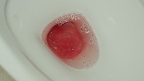 Bloody-urine-hitting-toilet-bowl,-close-up