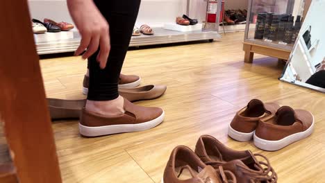 Lady-in-a-shoe-shop-trying-new-pairs-of-comfortable-shoes,-sneakers