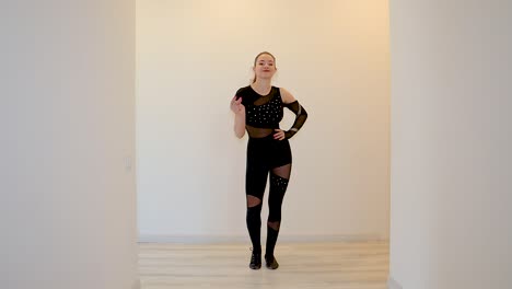 Young-and-attractive-female-dance-performer-dancing-alone-inside-a-home-wearing-a-dark-outfit-in-slow-motion