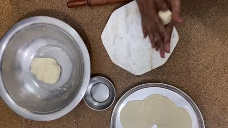 Close-up-shot-of-female-hands-kneading-dough-of-wheat-flour-before-making-roti-in-a-kitchen