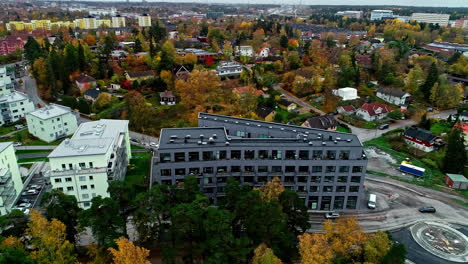 Aerial-drone-rotating-shot-over-residential-buildings-along-Stockholm-suburb-surrounded-by-autumnal-trees-in-Sweden-at-daytime