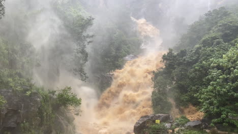 Handaufnahme-Von-Ravana-Wasserfällen-Bei-Hohem-Abfluss,-Nachdem-Heftige-Regenfälle-In-Ella,-Sri-Lanka,-Schlammiges-Wasser-überschwemmt-Haben