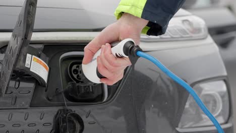 Removing-charging-cable-and-close-lid-on-Hyunday-electric-vehicle,-closeup