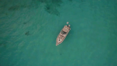 Cinematic-drone-clip-moving-downwards-towards-a-luxurious-boat-in-an-exotic-ocean-area