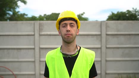 Construction-Worker-In-Yellow-Hard-Hat-And-Reflective-Vest-Pointing-Finger-To-Head