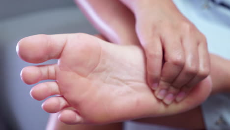 Close-up-of-an-individual-squeezing-her-foot-from-the-toes-to-her-heel-to-get-some-relief-from-inflammation-and-pain