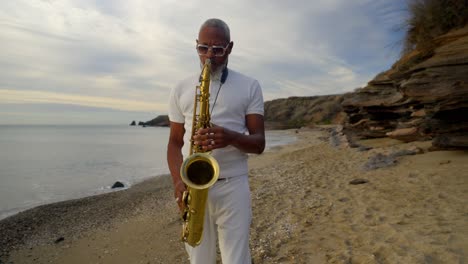 Langsam-Umlaufende-Aufnahme-Eines-Afroamerikanischen-Mannes,-Der-Am-Strand-Saxofon-Spielt