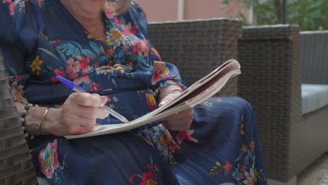 Slow-motion-shot-of-an-elderly-woman-doing-a-puzzle-in-the-garden