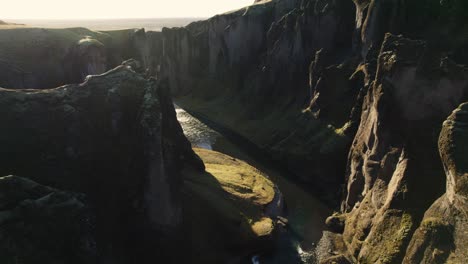 -Famous-canyon-in-Iceland,-Fjaðrárgljúfur,-aerial-establisher-in-golden-sunset