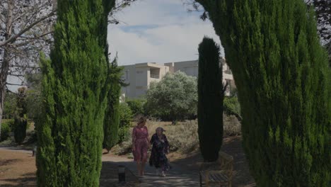 Slow-motion-shot-of-a-elderly-woman-walking-with-her-daughter-in-a-garden