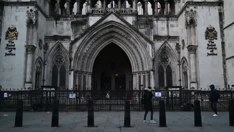 Walking-past-The-Royal-Courts-of-Justice,-London,-United-Kingdom