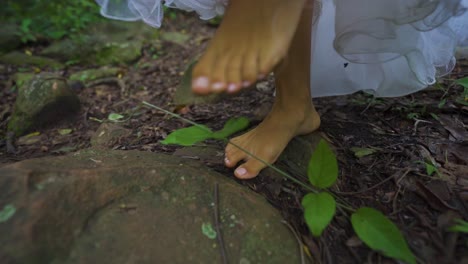 Weibliche-Füße,-Die-Auf-Der-Erde-Und-Steinen-Im-Dschungel-Laufen