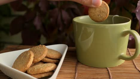 Person-enjoying-cookies-and-tea-on-terrace-at-autumn