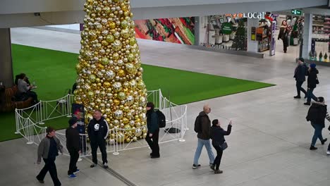 Gente-Caminando-Por-El-árbol-De-Navidad-Dentro-De-La-Estación-De-Waterloo,-Londres,-Reino-Unido